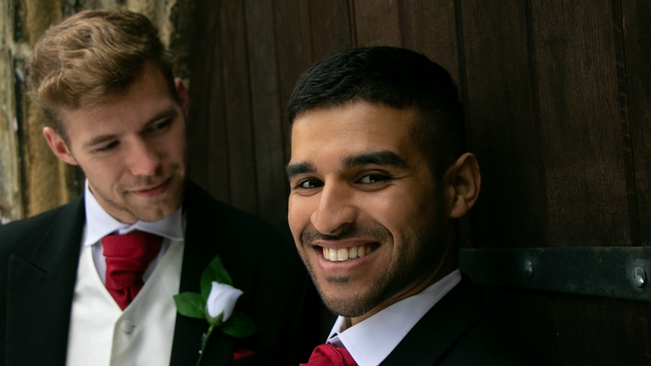 Couple d'hommes, jeunes mariés, devant une église