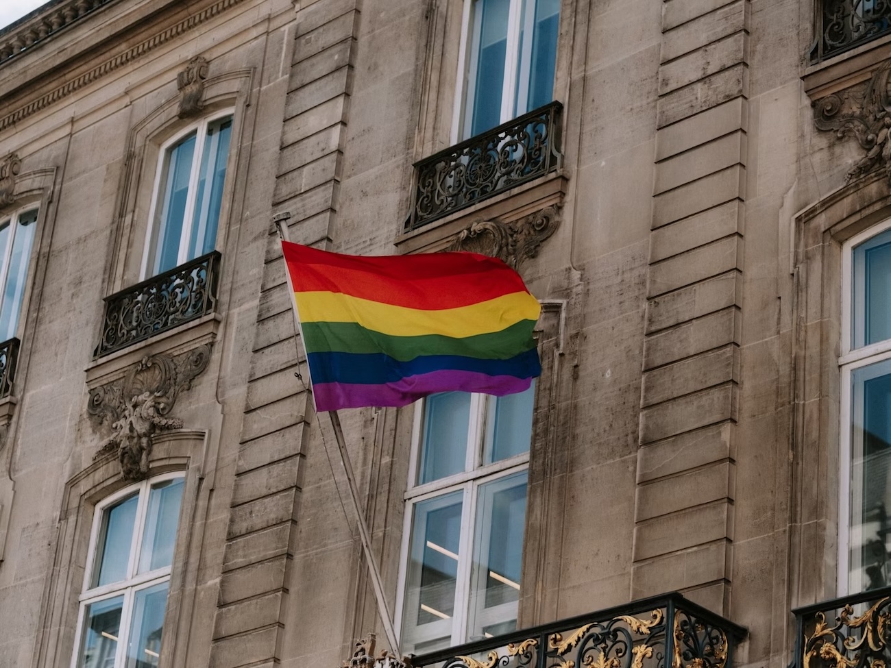 Un drapeau arc-en-ciel sur la façade d'un immeuble