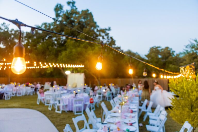 Réception de mariage en plein air au coucher du soleil, de charme, illuminée par des guirlandes lumineuses